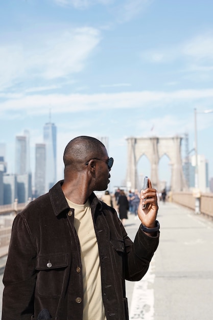 Free photo young stylish man exploring a city bridge by himself