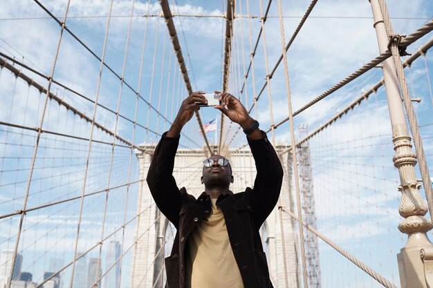 Young stylish man exploring a city bridge by himself