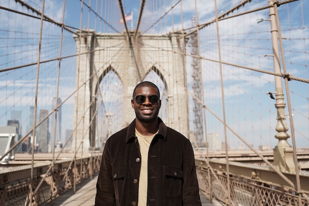 Foto gratuita giovane uomo alla moda che esplora da solo un ponte della città