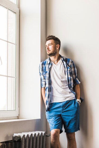 Young stylish man looking at window