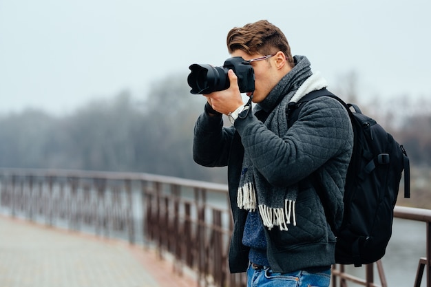 세련 된 젊은 사진 작가 사진을 찍고 전문 카메라를 보유하고있다.