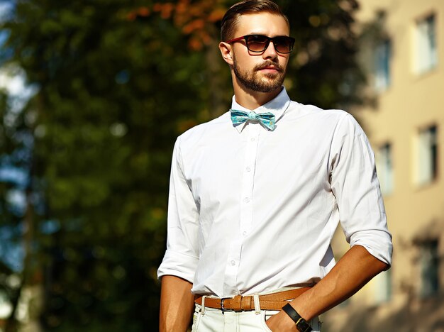 メガネの通りのカジュアルな布ライフスタイルで若いスタイリッシュなセクシーなハンサムなモデル男