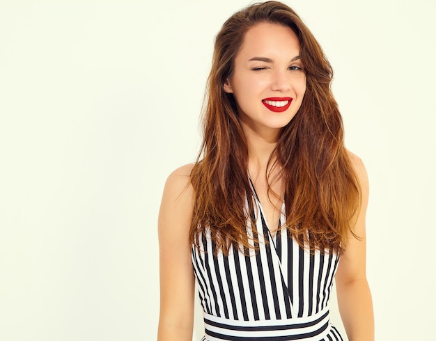 Young stylish smiling woman model in casual summer striped suit with red lips, isolated. winking