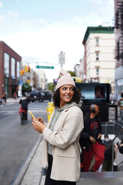 Молодая стильная женщина в городе с помощью смартфона для исследования