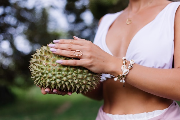 Young stylish woman holding durian fruit