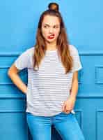 Foto gratuita modello di giovane donna alla moda in abiti casual estivi con labbra rosse, in posa vicino alla parete blu