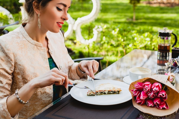 Young stylish woman sitting in cafe, eating tasty pie