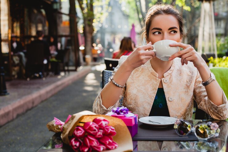 Free Photo young stylish woman sitting in cafe, holding cup of cappuccino