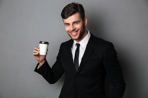若い成功した実業家が彼の朝のコーヒーを面白がって、
