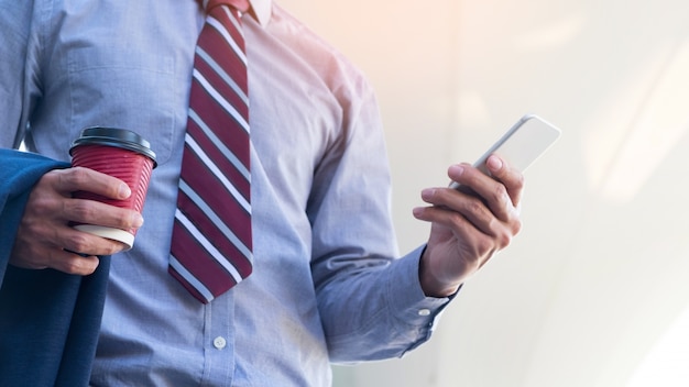 Young and successful businessman is reading a message on his smartphone.