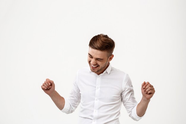 Young successful businessman laughing, rejoicing.