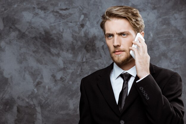 Young successful businessman speaking on phone