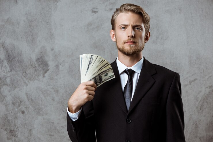 Free Photo young successful businessman in suit holding money