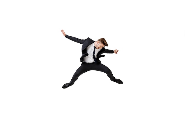 Young successful businessman in suit rejoising, jumping on white
