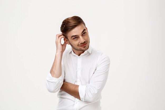 Young successful businessman thinking, posing.