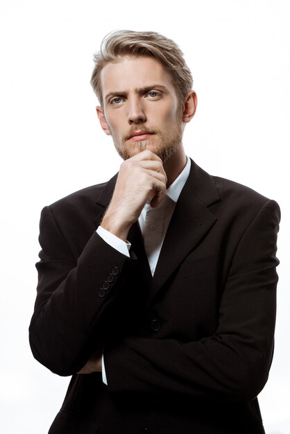 Young successful businessman thinking with hand on chin 