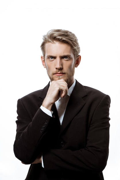 Young successful businessman thinking with hand on chin 