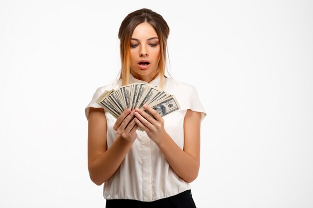 young successful businesswoman holding money over white background.