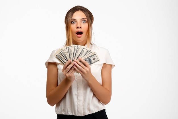 young successful businesswoman holding money over white background.