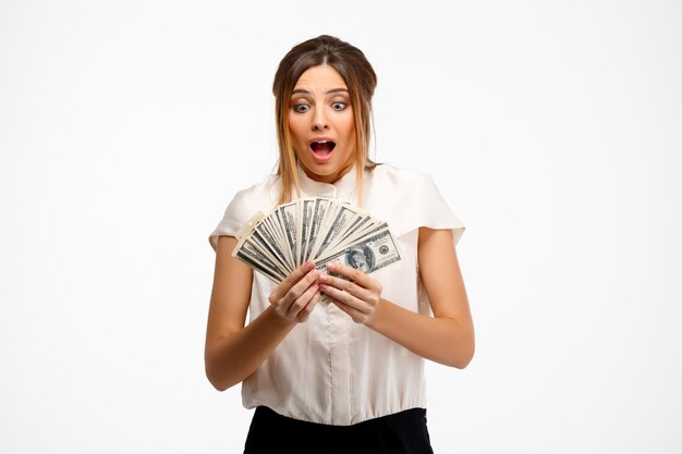 young successful businesswoman holding money over white background.