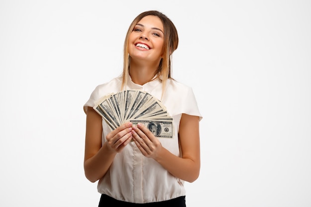 young successful businesswoman holding money over white background.