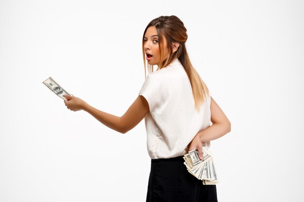 young successful businesswoman holding money over white background.