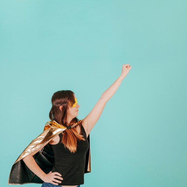 Young superwoman in flying pose