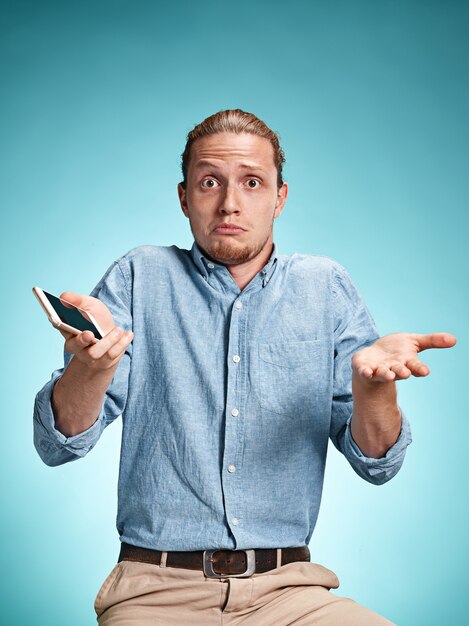 The young surprised caucasian man on blue background