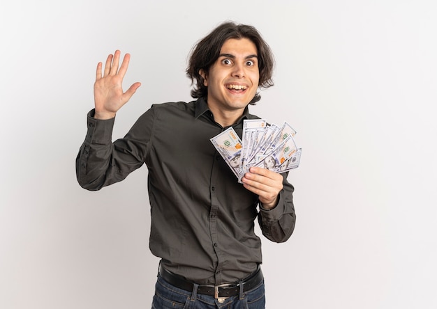 young surprised handsome caucasian man holds money and raises hand