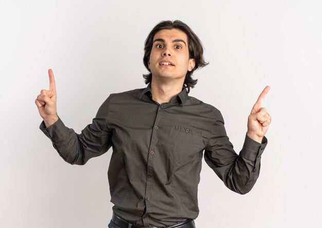 Young surprised handsome caucasian man points up isolated on white background with copy space