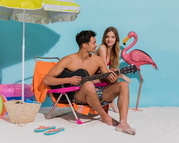 Young sweethearts relaxing on beach in studio