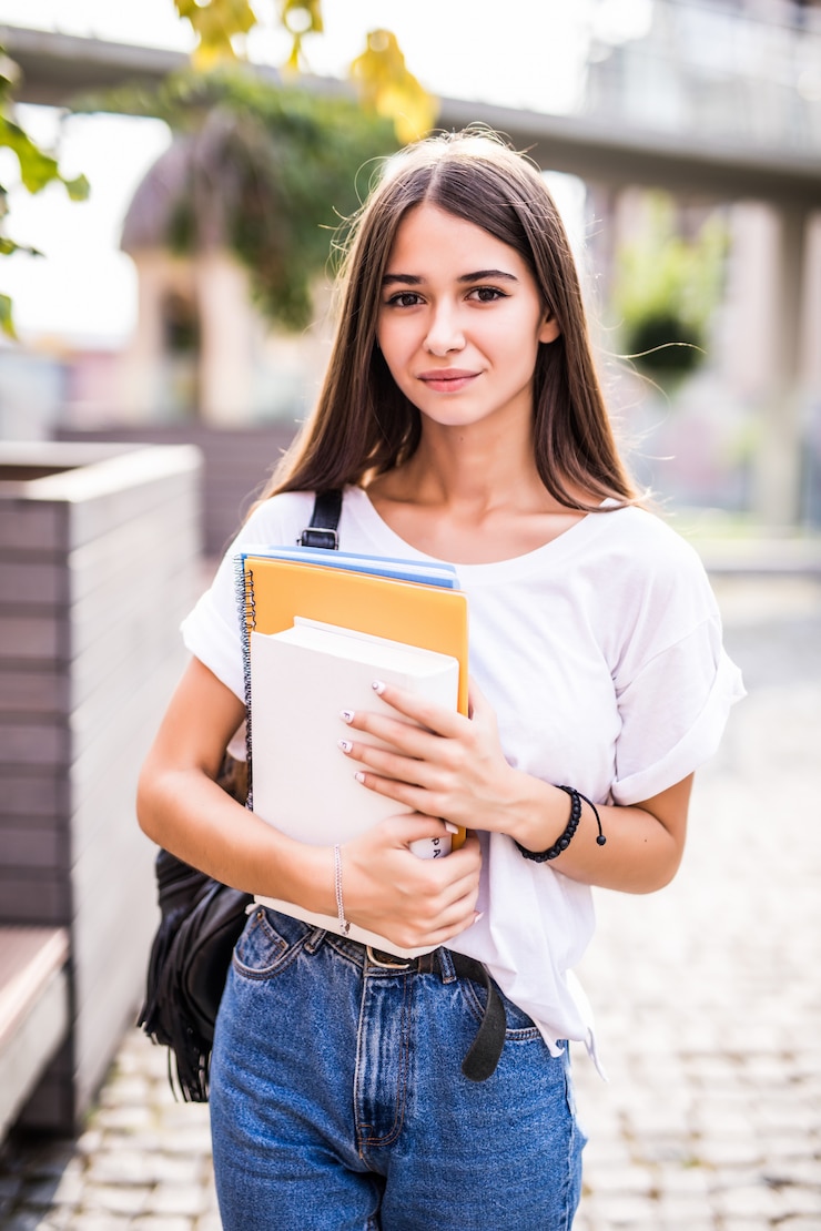 Free Photo young talented female student dressed in casual clothing walking around city. attractive brunette woman enjoying free time outdoors