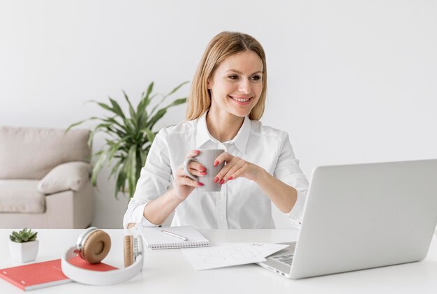 Young teacher paying attention to her students while having some coffee