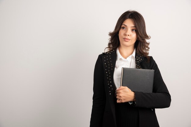 Young teacher posing with book on white.