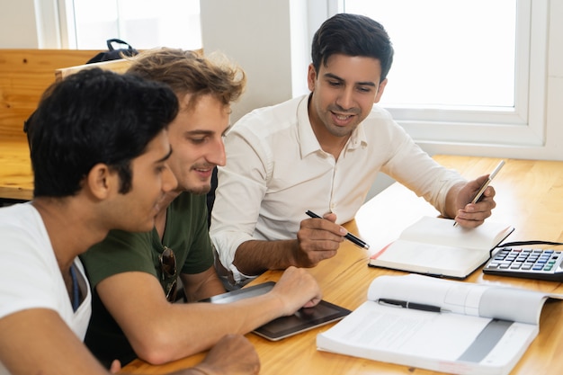 Free photo young teacher telling two students about corporate budgeting