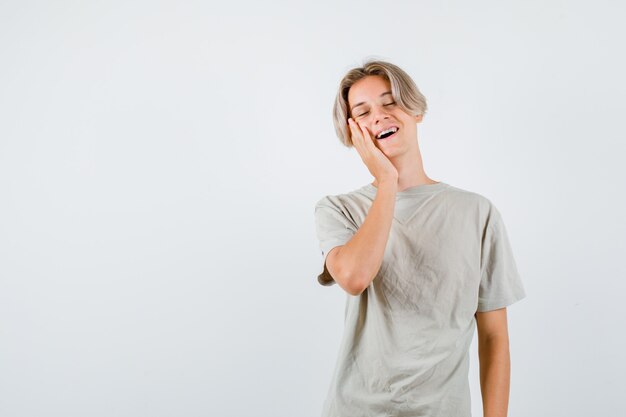 Young teen boy leaning cheek on hand