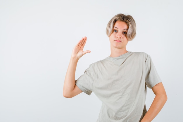 Young teen boy showing bla-bla-bla gesture in t-shirt and looking bored