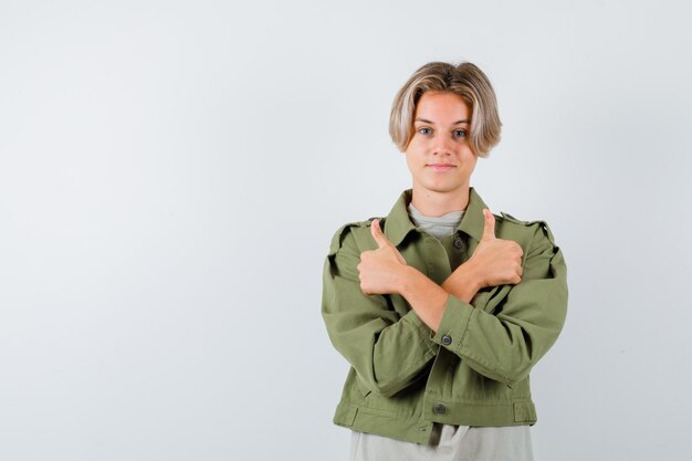 Young teen boy showing double thumbs up in t-shirt, jacket and looking confident , front view.