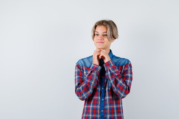 Young teen boy with hands under chin