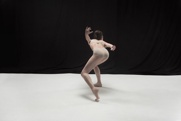 Young teen dancer dancing on white floor studio background. Ballerina project.