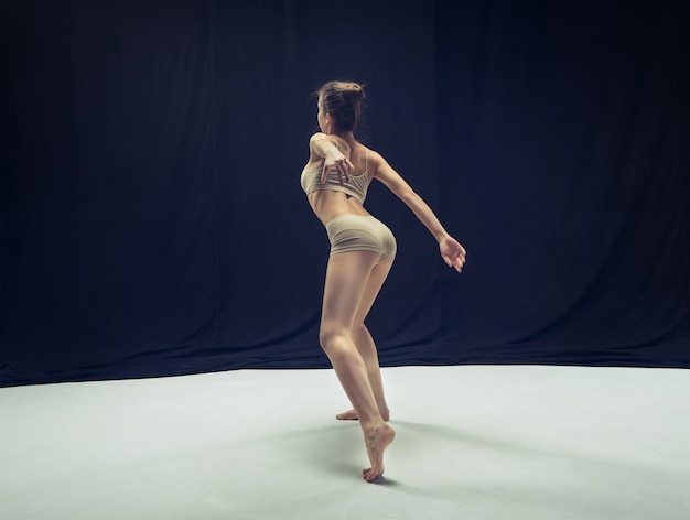 Молодой подросток танцор танцует на белой студии пола.