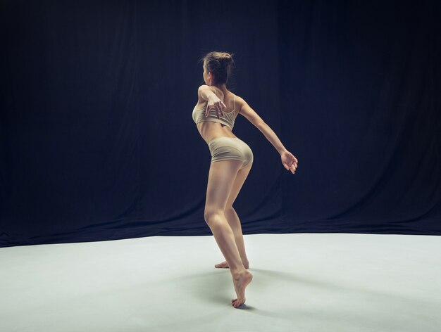 白い床のスタジオで踊る若いティーンダンサー。