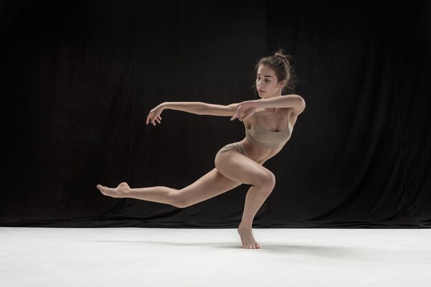 Young teen dancer on white floor.