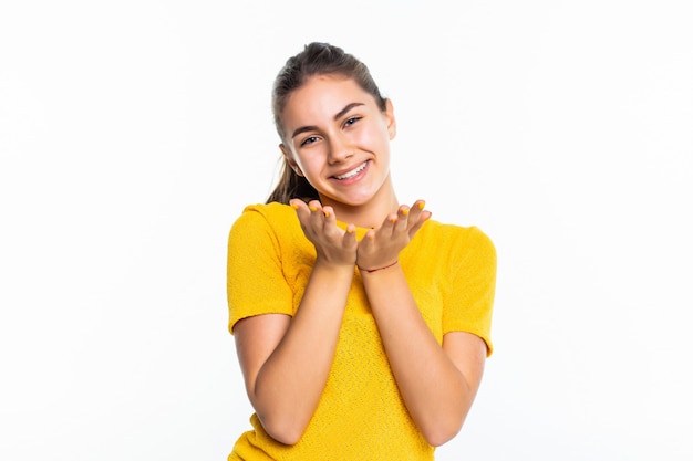 Young teen girl blowing kiss isolated on white wall