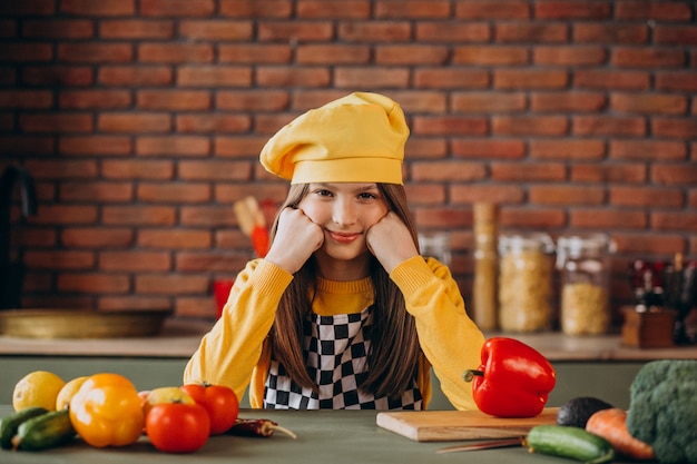 Free photo young teen girl preparing salad for breakfast at the kitchen