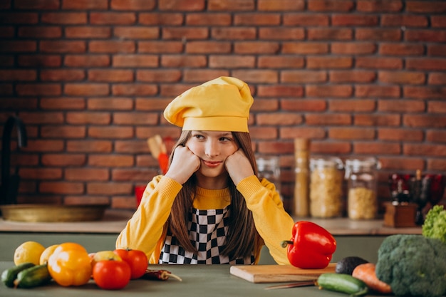 Free photo young teen girl preparing salad for breakfast at the kitchen