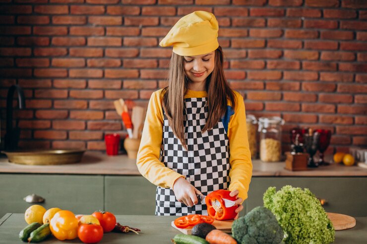 Free Photo young teen girl preparing salad for breakfast at the kitchen