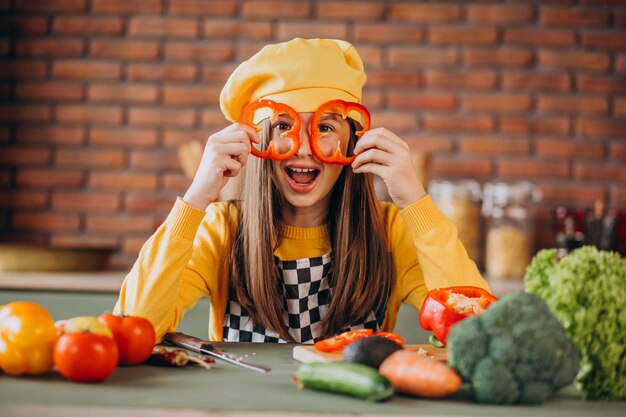 Young teen girl preparing salad for breakfast at the kitchen