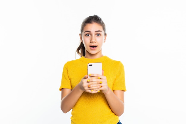 Young teen girl use of the cellphone isolated on white wall