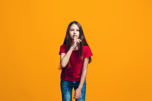 The young teen girl whispering a secret behind her hand